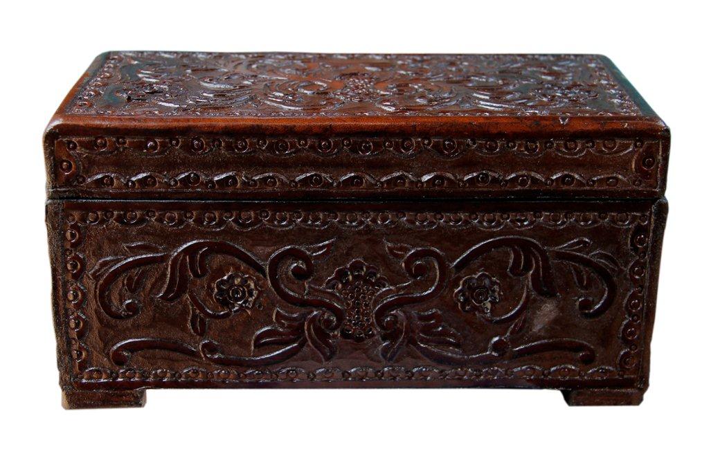 A hand tooled leather box with floral patterns and a dark brown finish.